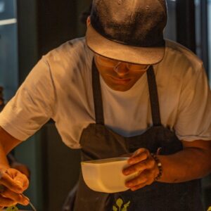 A man in a hat is preparing food on a table